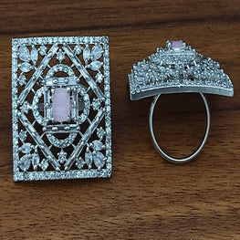 Diamond-encrusted ring and brooch on a wooden surface
