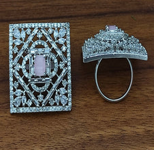 Diamond-encrusted ring and brooch on a wooden surface