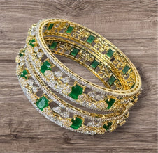 Gold and green gemstone bangles on a wooden surface