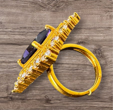 Gold ring with blue gemstone on a wooden surface