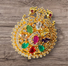 Decorative ring with gold, gemstones, and intricate design on a wooden surface