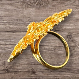 Gold ring with decorative design on a wooden surface