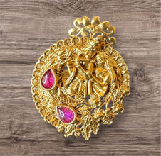 Decorative gold Ring with pink gemstones on a wooden surface